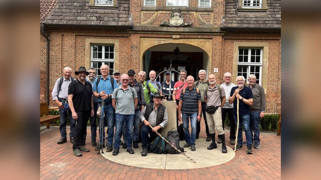 Gruppe von Männern mit Wanderstöcken vor dem Marstall Clemenswerth in Sögel