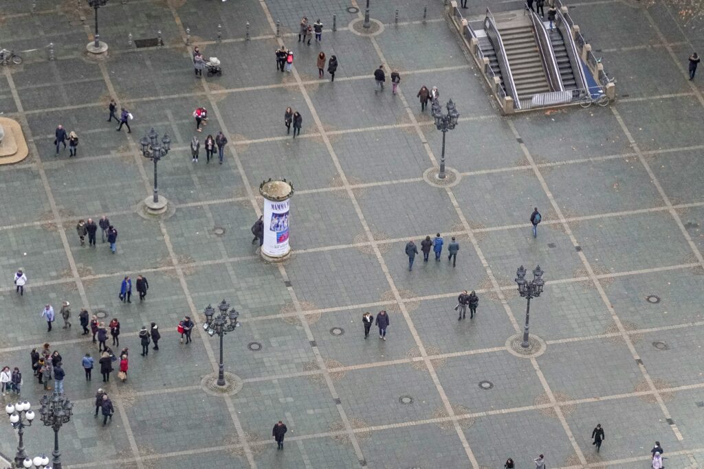 Menschen überqueren einen belebten Platz, Symbolbild für die Bevölkerungsstatistik