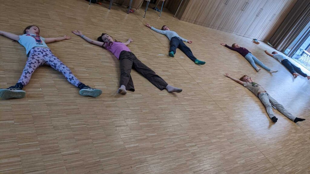 Kinder bewegen sich in einem Saal des einsA in Tierrollen durch den Raum