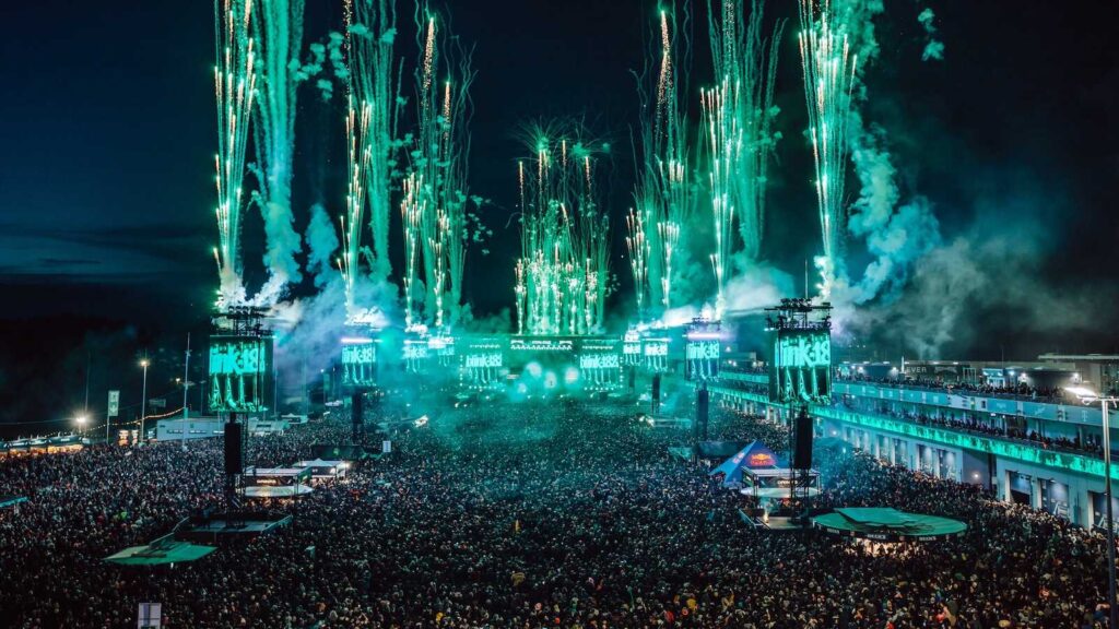 Nächtliche Festivalbühne mit grünem Feuerwerk und dichtem Publikum bei Rock am Ring