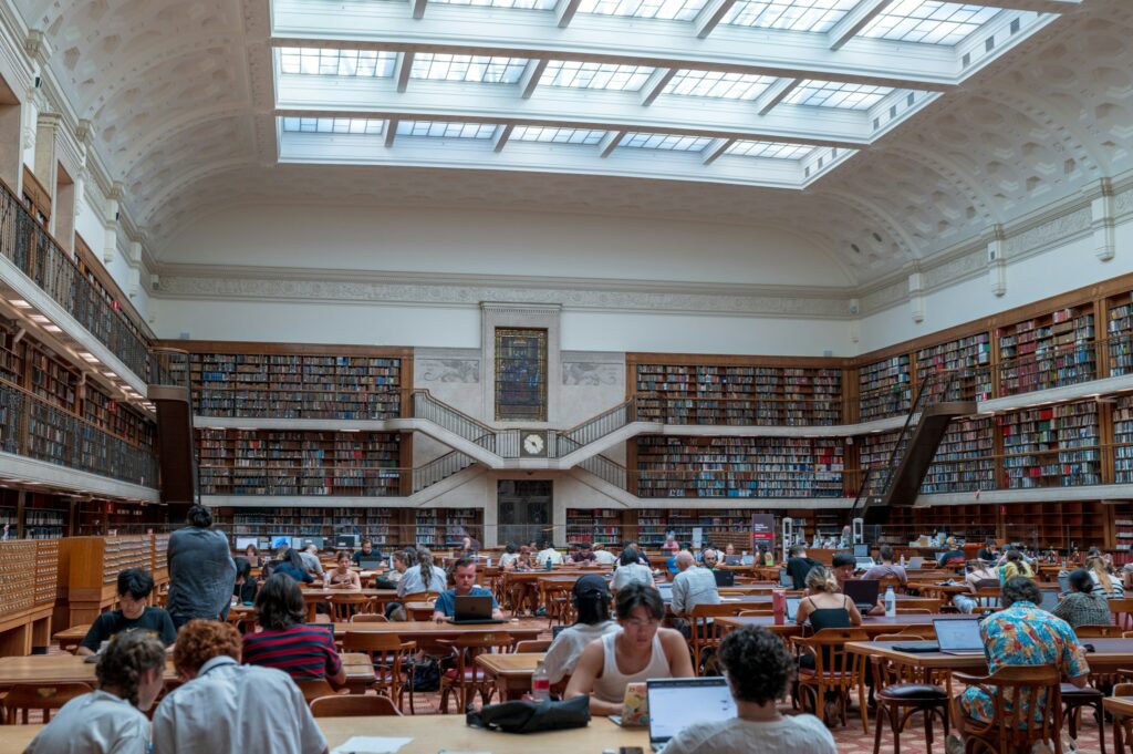 Studierende arbeiten in einer grossen Hochschulbibliothek, Symbolbild fuer Promotionsverfahren in Deutschland