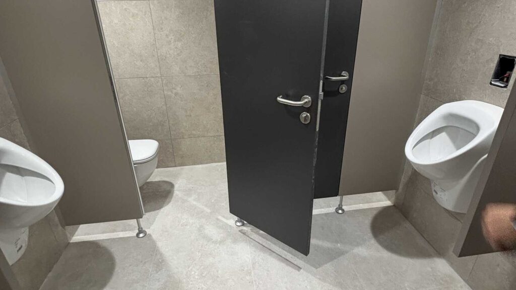 Sanierte öffentliche Toilette im Rathaus Rhede mit Waschbecken und Wänden in Grautönen