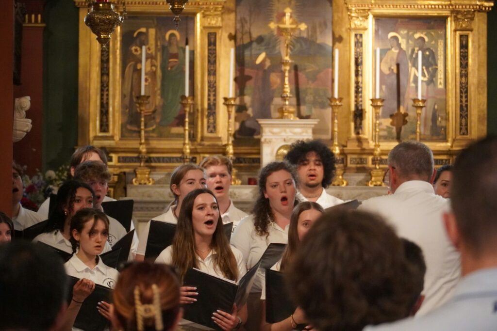 Chor beim gemeinsamen Singen, Dirigent im Vordergrund