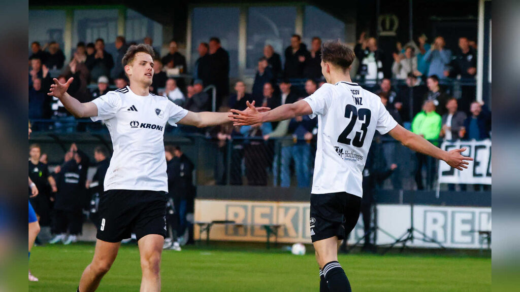 Zwei Fußballer des SC Spelle-Venhaus im weißen Trikot klatschen sich nach einem Tor ab