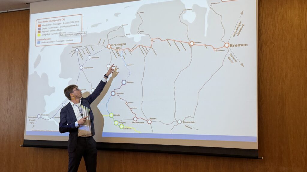 Paul Kamps zeigt bei der Bahnkonferenz in Ihrhove eine Karte der grenzüberschreitenden Bahnprojekte zwischen Deutschland und den Niederlanden
