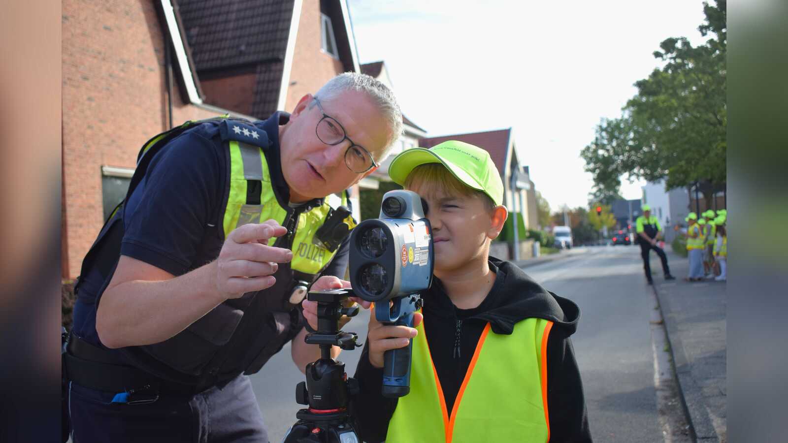 Kinder kontrollieren mit einem Radargerät die Geschwindigkeit vorbeifahrender Fahrzeuge