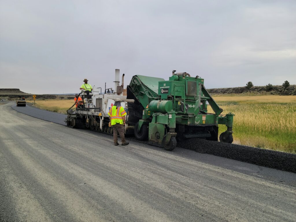 Frischer Asphalt wird auf einer Straße eingebaut (Symbolbild)