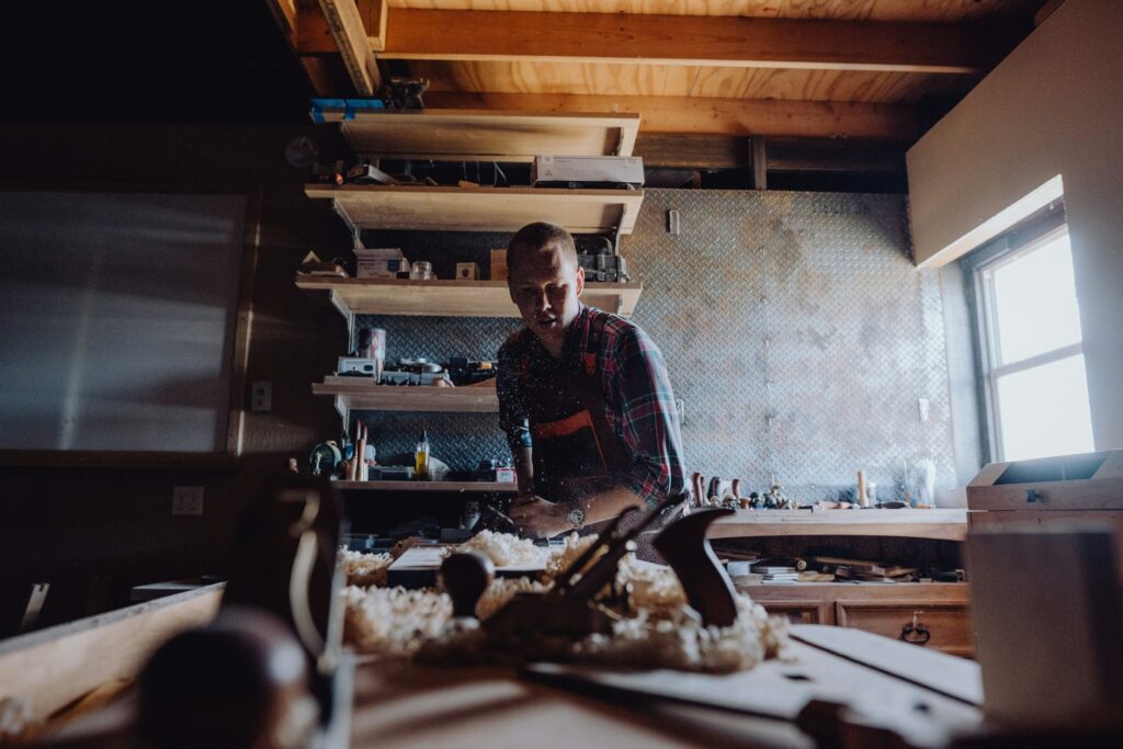Junger Mann arbeitet an einem Werkstück in einer Werkstatt – Symbolbild für Ausbildung und Berufsorientierung