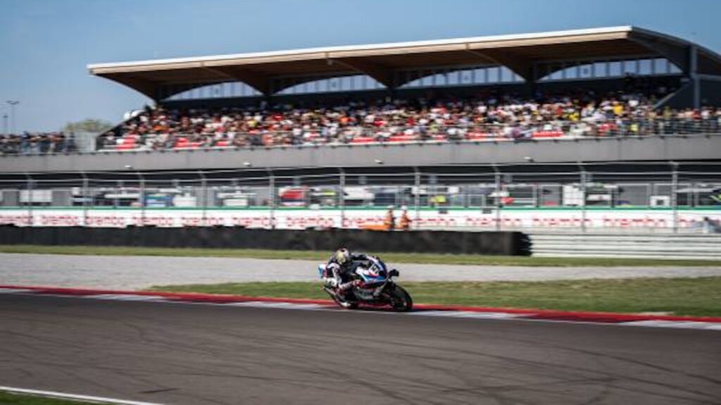 Fahrer des ROKiT BMW Motorrad WorldSBK Teams auf der BMW M 1000 RR vor der vollbesetzten Haupttribüne in Cremona