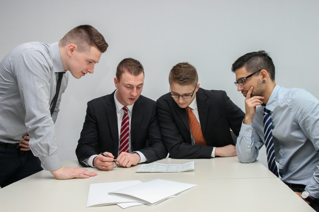 Mehrere Personen besprechen Unterlagen am Tisch (Symbolbild)