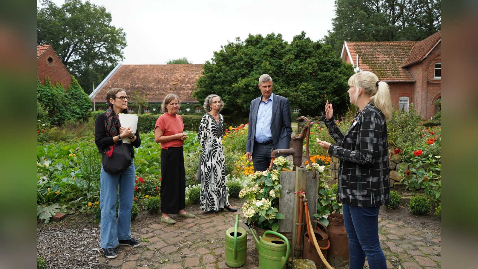 Sarah Dirksen führt den Besuch der Bingo-Umweltstiftung über den Kossehof der VHS Meppen