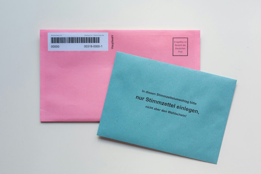 Ein blauer Briefumschlag liegt auf einem weißen Tisch