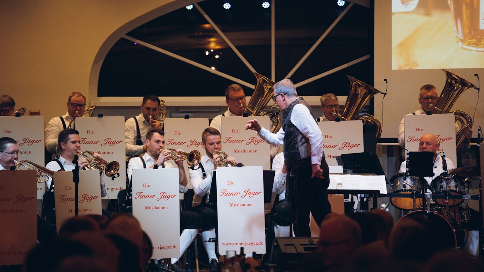 Dirigent Florian Gerdes dirigiert die Tinner Jäger Musikanten auf der Bühne