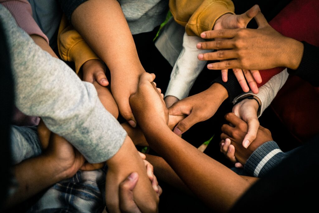 Menschen halten sich als Symbol für ehrenamtliches Engagement an den Händen