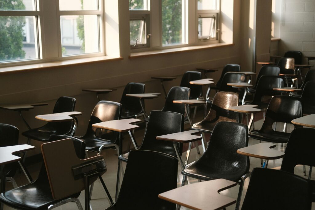 Leeres Klassenzimmer mit Tischen und Stühlen, Symbolbild zu Eingliederungshilfen und Schulbegleitung