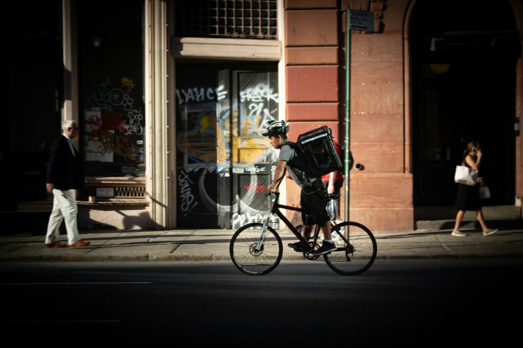 Fahrradkurier mit Lieferrucksack im Stadtverkehr