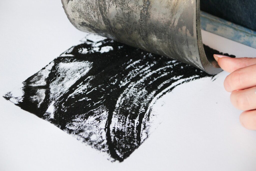 Hand druckt mit schwarzer Farbe auf Papier, Druckgrafik (Symbolbild)