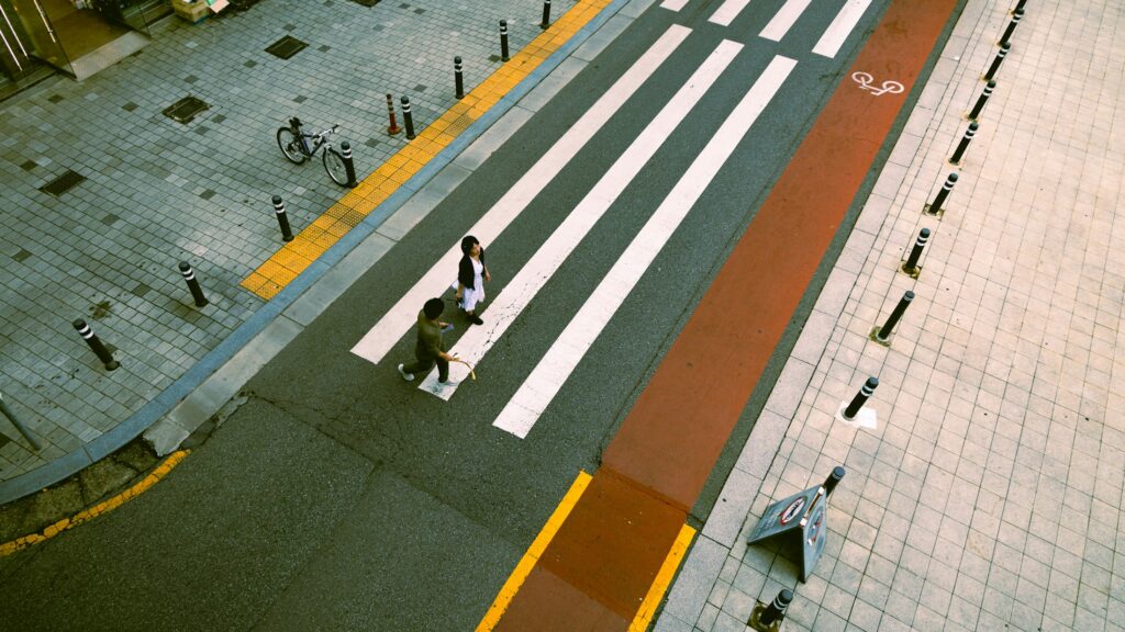 Zwei Menschen überqueren einen Zebrastreifen in einer Stadt (Symbolbild zum Fußverkehr)