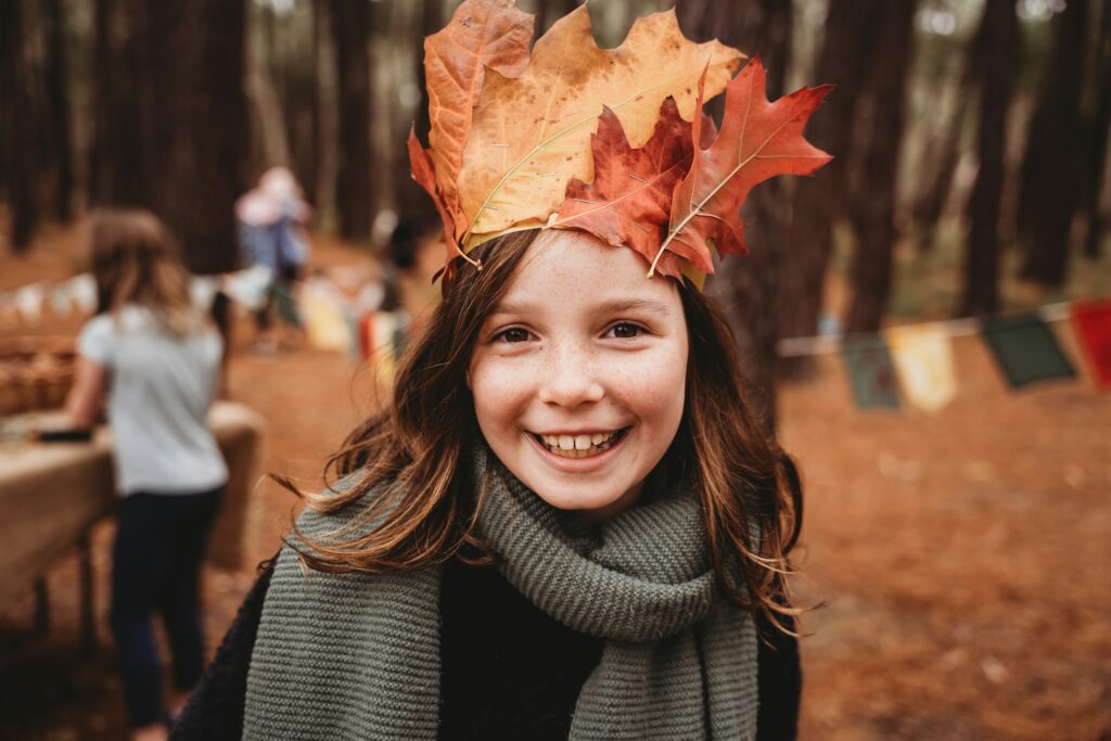 Symbolbild: Kind mit Herbstlaub im Freien