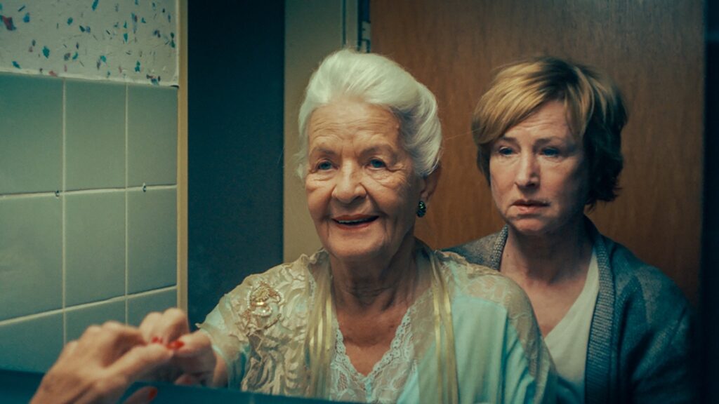 Filmszene aus „Im Spiegel meiner Mutter“: Hildegard Schmahl und Corinna Harfouch vor einem Spiegel im Badezimmer