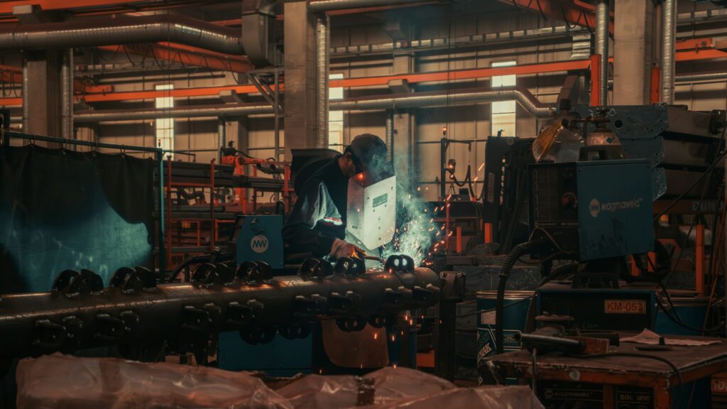 Industriearbeiter beim Schweißen in einer Produktionshalle, Symbolbild für die Industrie im Oldenburger Land