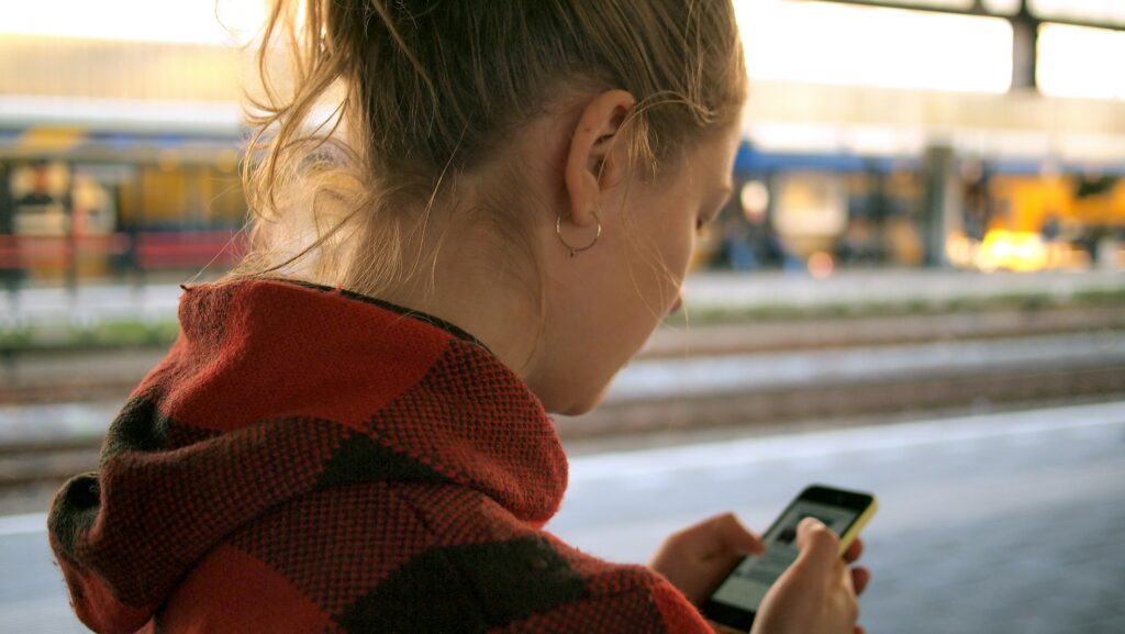 Junge Frau blickt auf ihr Smartphone
