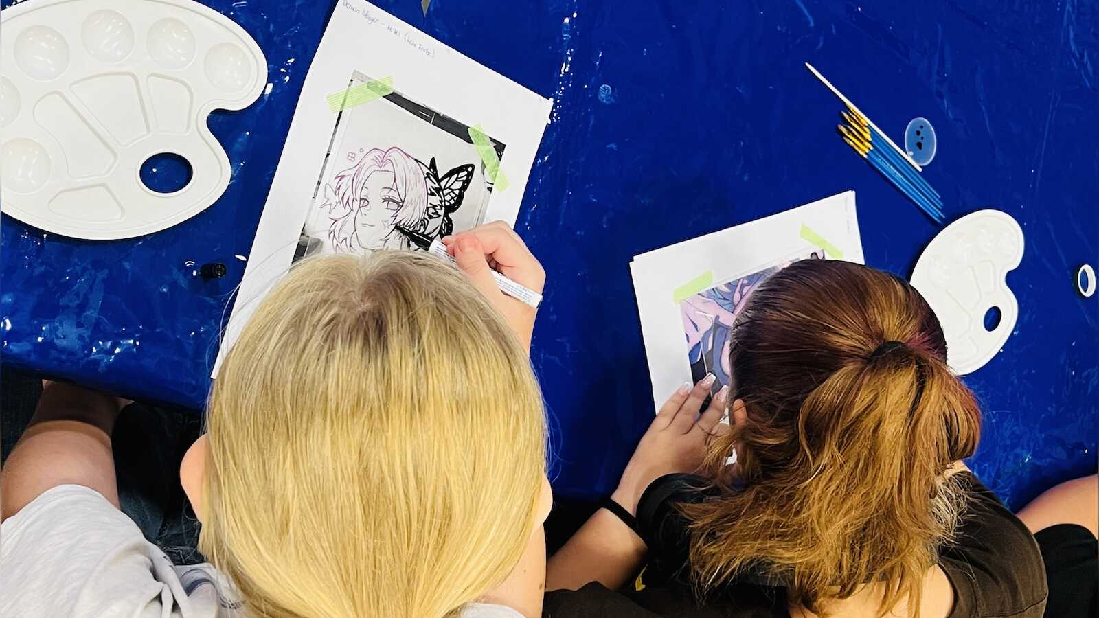 Teilnehmende zeigen ihre selbst gestalteten Manga- und Anime-Glasbilder aus dem SommerLeseClub-Workshop