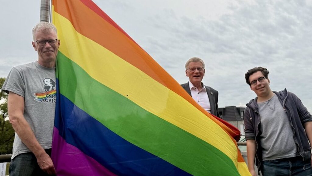 Bürgermeister Horst Feddermann steht mit Stefan Obermaier und Benedict Holtsteger vom CSD Aurich im Auricher Rathaus