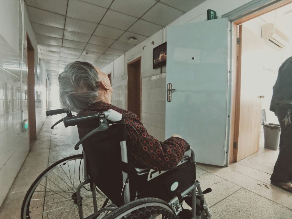 Ältere Frau sitzt in einem Rollstuhl