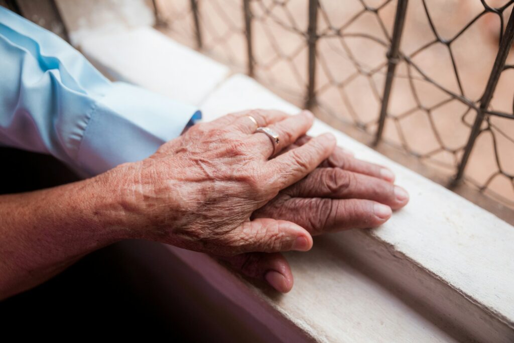 Ältere Person hält die Hand einer jüngeren Person