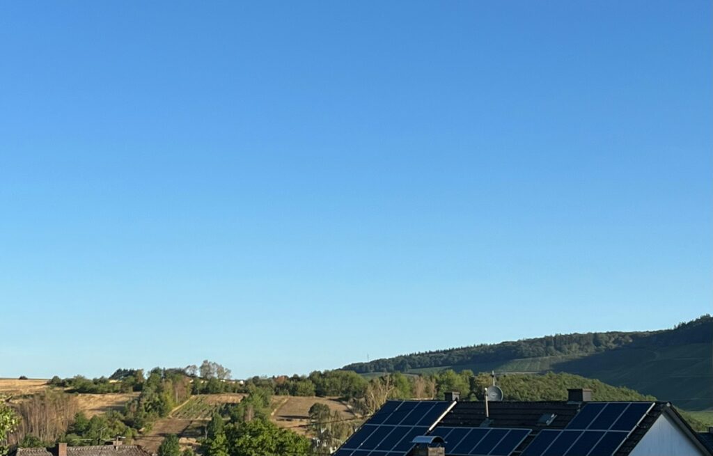 Solarmodule auf einem Hausdach unter blauem Himmel