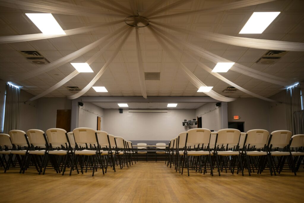 Leerer Saal mit aufgereihten Stühlen, Symbolbild für eine Sitzung