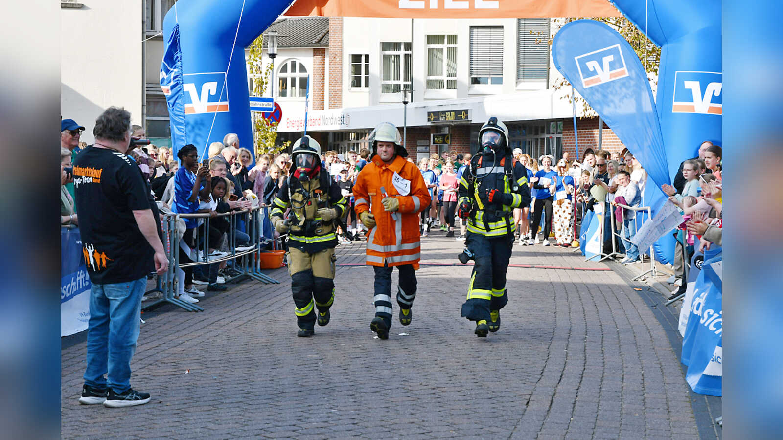 Feuerwehrleute laufen in voller Einsatzmontur beim Staffellauf des Cloppenburger Citylaufs