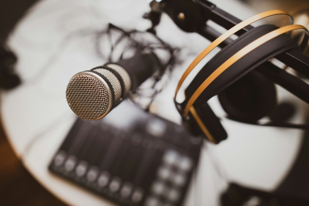 Podcast-Mikrofon und Kopfhörer auf einem Schreibtisch (Symbolbild)