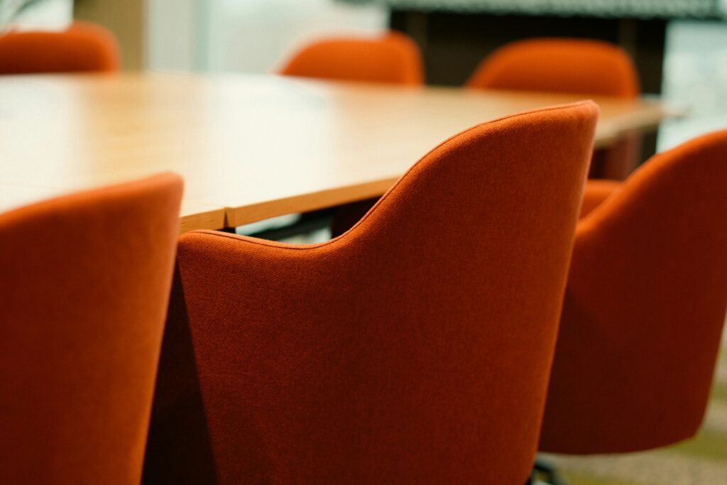 Leerer Sitzungsraum mit Stühlen um einen Tisch, Symbolbild für Gremiensitzung