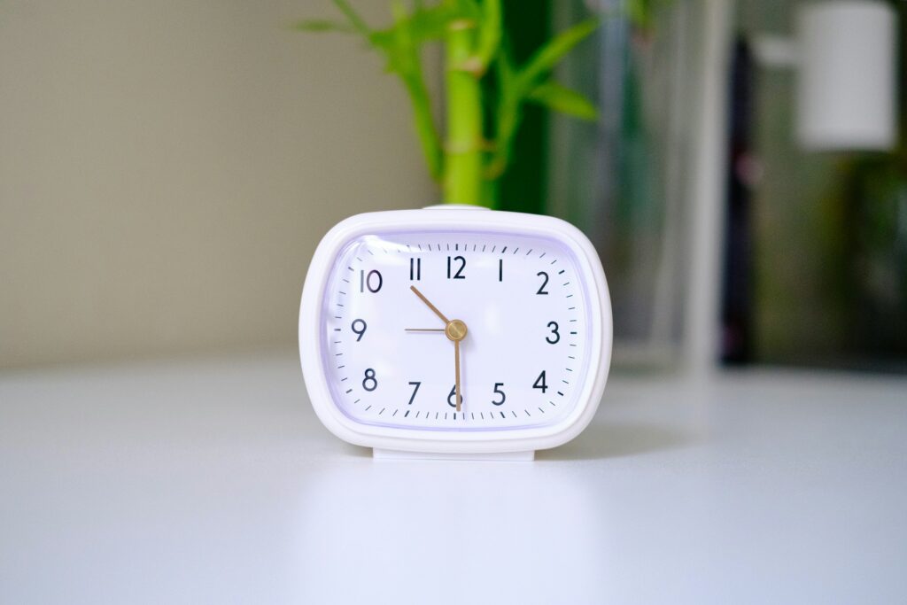 Weiße Uhr auf einem Tisch als Symbolbild für Arbeitszeitwünsche