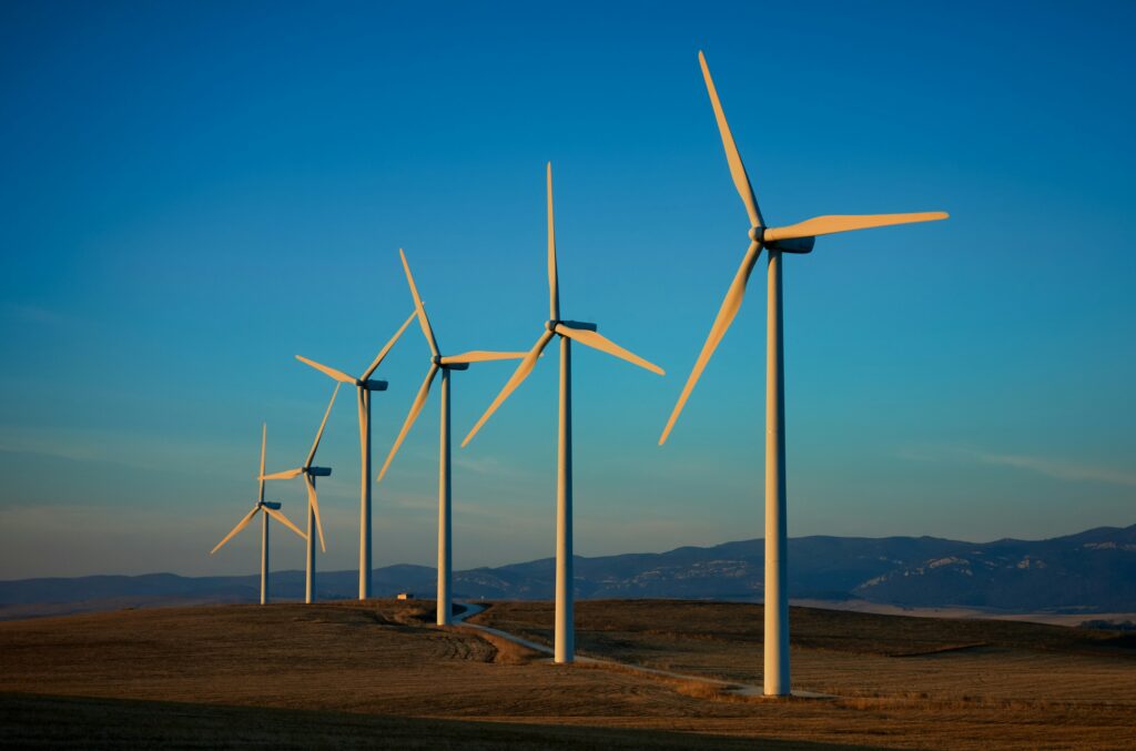 Reihe von Windrädern auf einem Feld als Symbolbild für erneuerbare Energien
