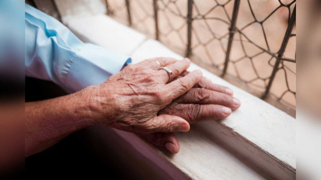 Ältere Person hält die Hand einer jüngeren Person, Symbolbild für häusliche Pflege