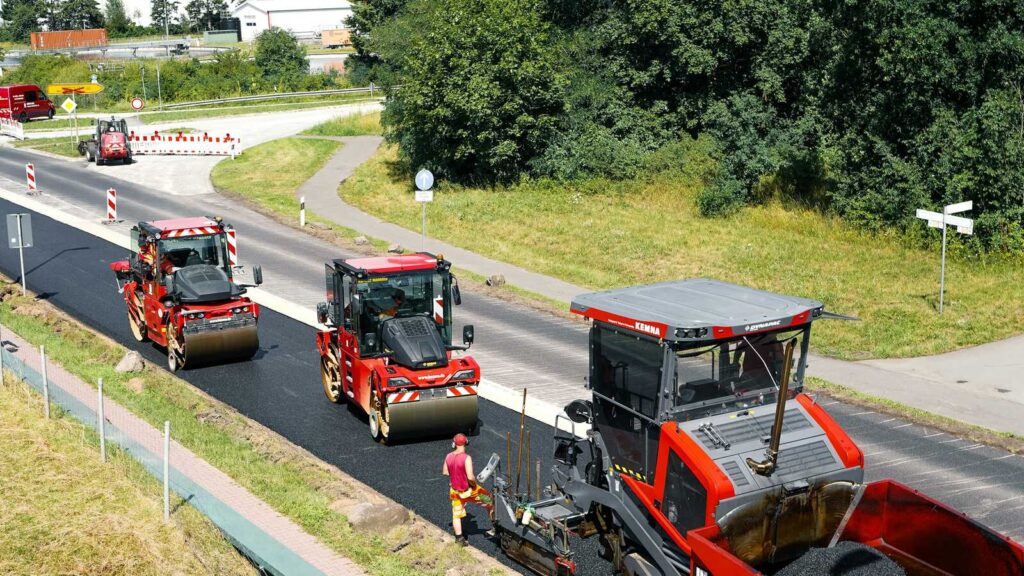 Straßenwalze verdichtet frischen Asphalt bei nächtlichen Bauarbeiten, Symbolbild
