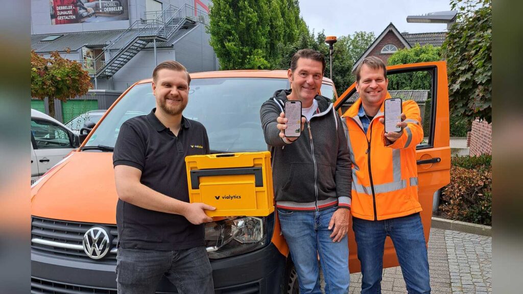 Alexander Block, Rainer Dasenbrock und Bauhofleiter Walter gr. Siemer präsentieren die vialytics-App auf einem Smartphone