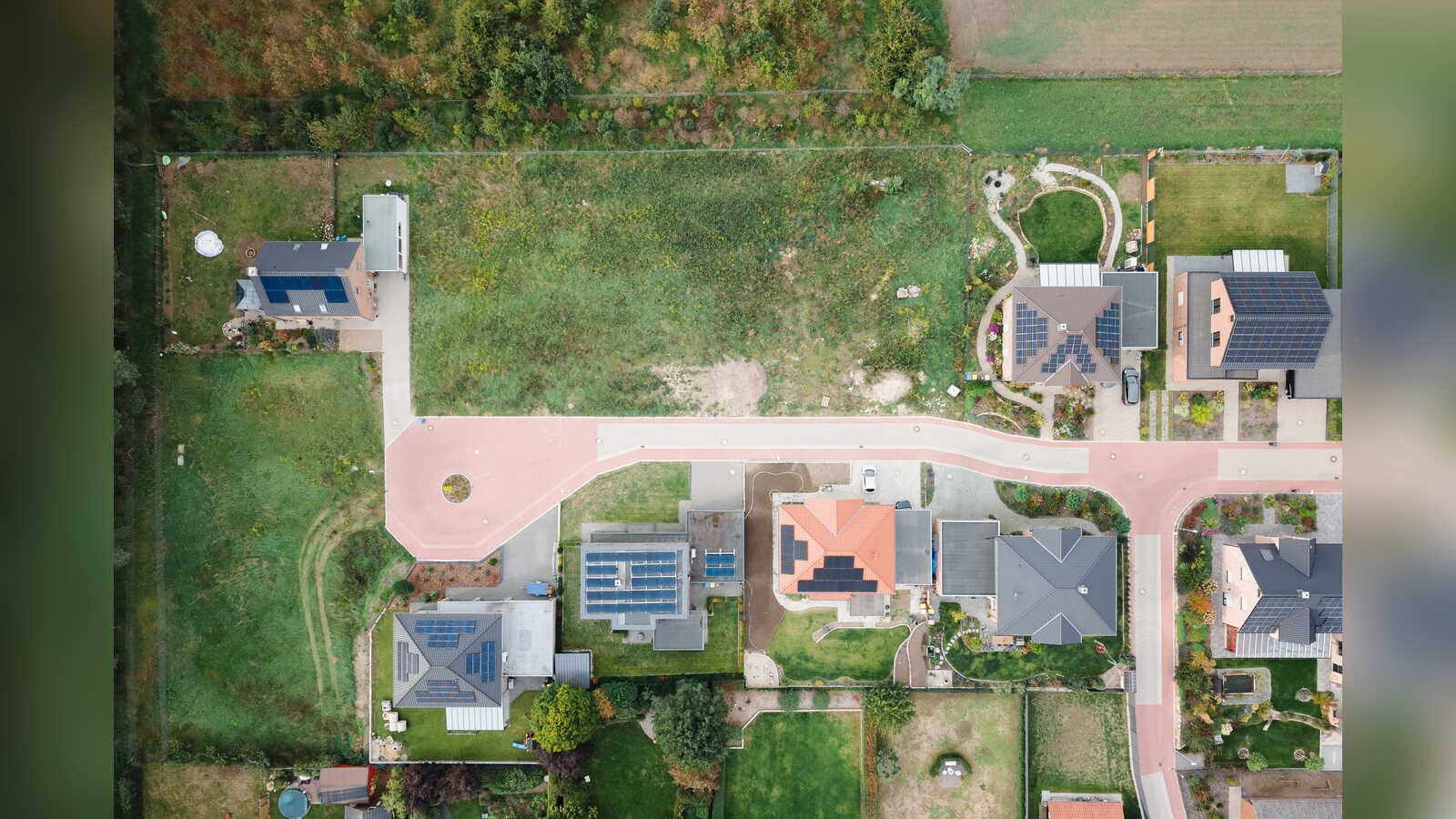 Senkrechte Drohnenaufnahme: Wendehammer und bebaute Grundstücke, daneben eine freie Rasenfläche im Baugebiet Ehrendorf