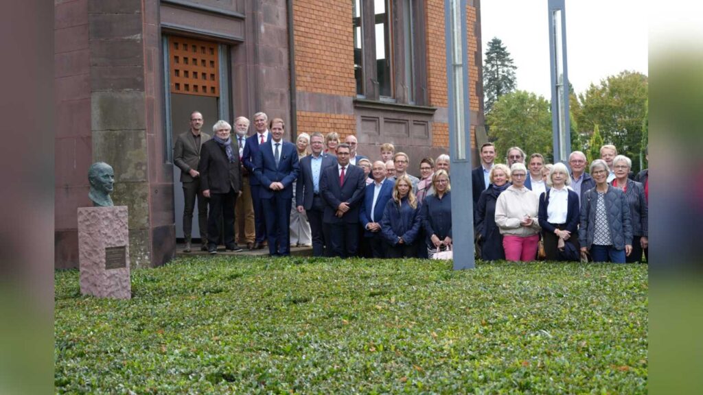 Gruppe von rund 40 Gästen vor dem Alten Landratsamt in Lüdinghausen, links die Bronzebüste von Paulus van Husen auf einem Steinsockel