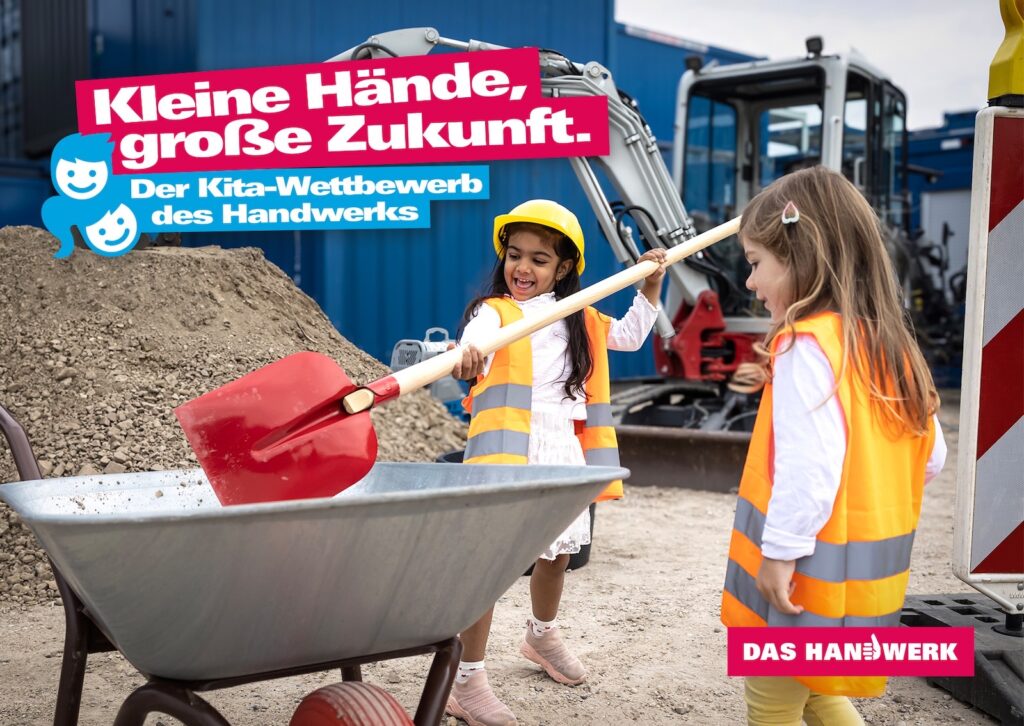 Zwei Mädchen in Warnwesten schaufeln auf einer Baustelle Erde in eine Schubkarre, dazu der Schriftzug Kleine Hände, große Zukunft