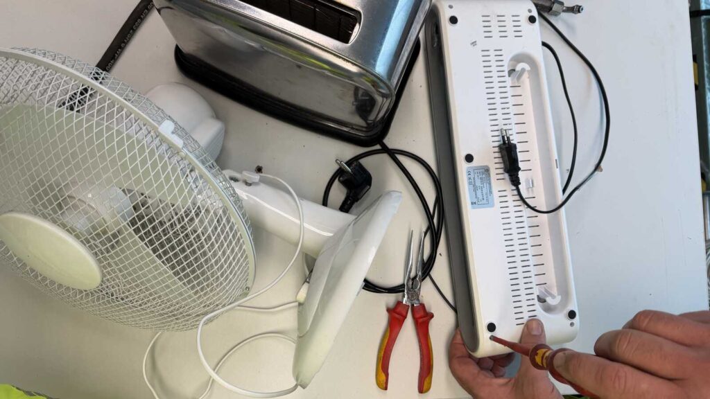 Reparatur eines Elektrogeräts in einem Repair Café, Motiv der AWIGO zum Thema Reparieren statt Wegwerfen