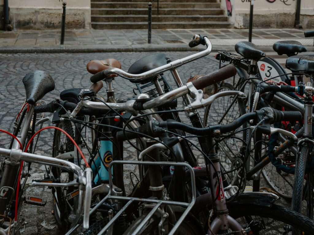 Mehrere abgestellte Fahrräder stehen auf einer gepflasterten Straße