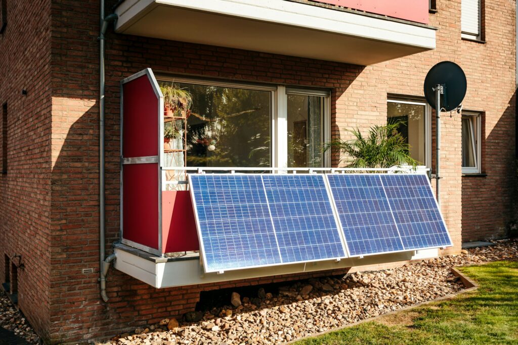 Kleines Solarmodul eines Balkonkraftwerks am Geländer eines Stadtbalkons