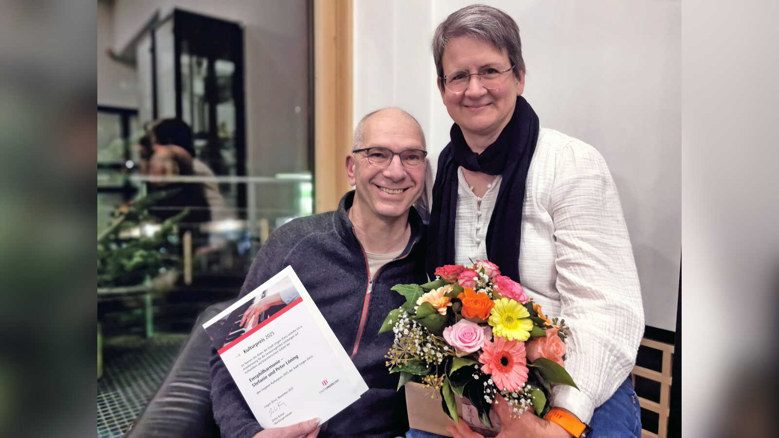 Peter und Stefanie Löning mit Urkunde und Blumenstrauß