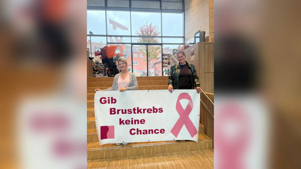 Gleichstellungsbeauftragte Jennifer Stocksley und einsA-Leiterin Sandra Allerdisse mit der rosa Schleife im einsA in Dülmen