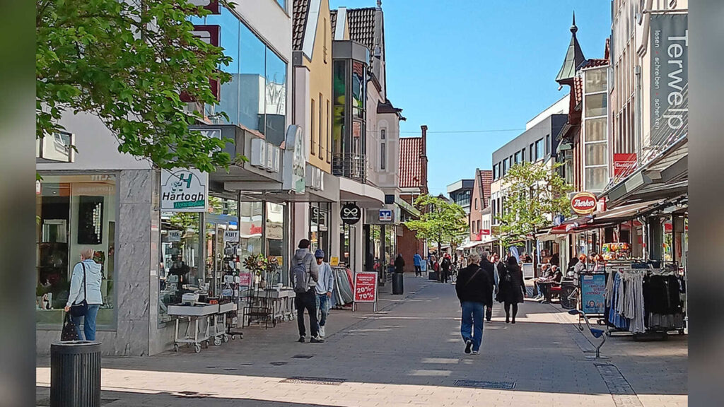 Blick in die Cloppenburger Fußgängerzone mit Geschäften und Passanten an einem sonnigen Tag