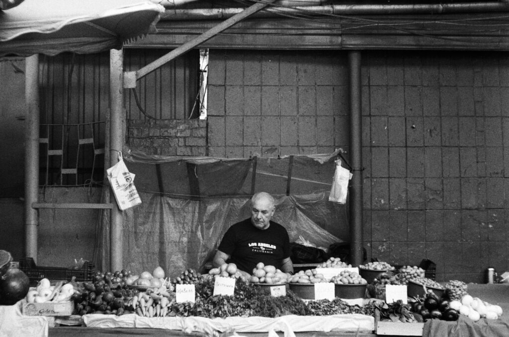 Händler verkauft Obst und Gemüse an einem Marktstand